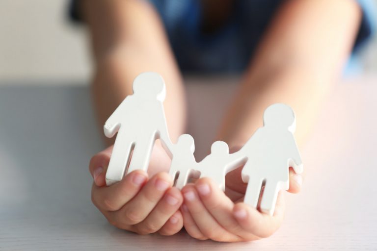 a hand holding a figurine of a family
