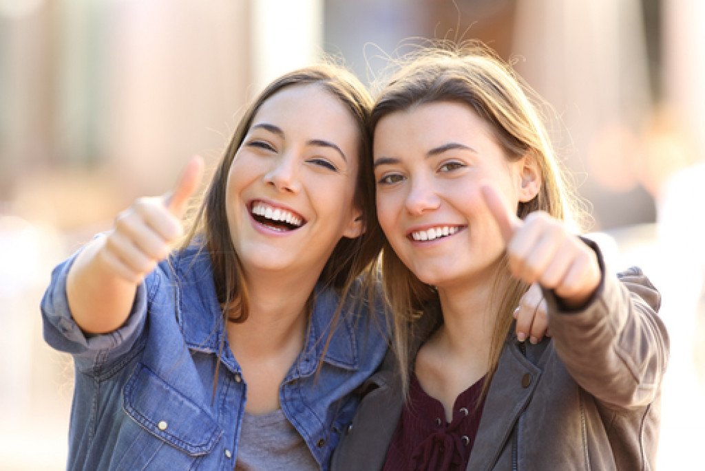 two women giving thumbs up